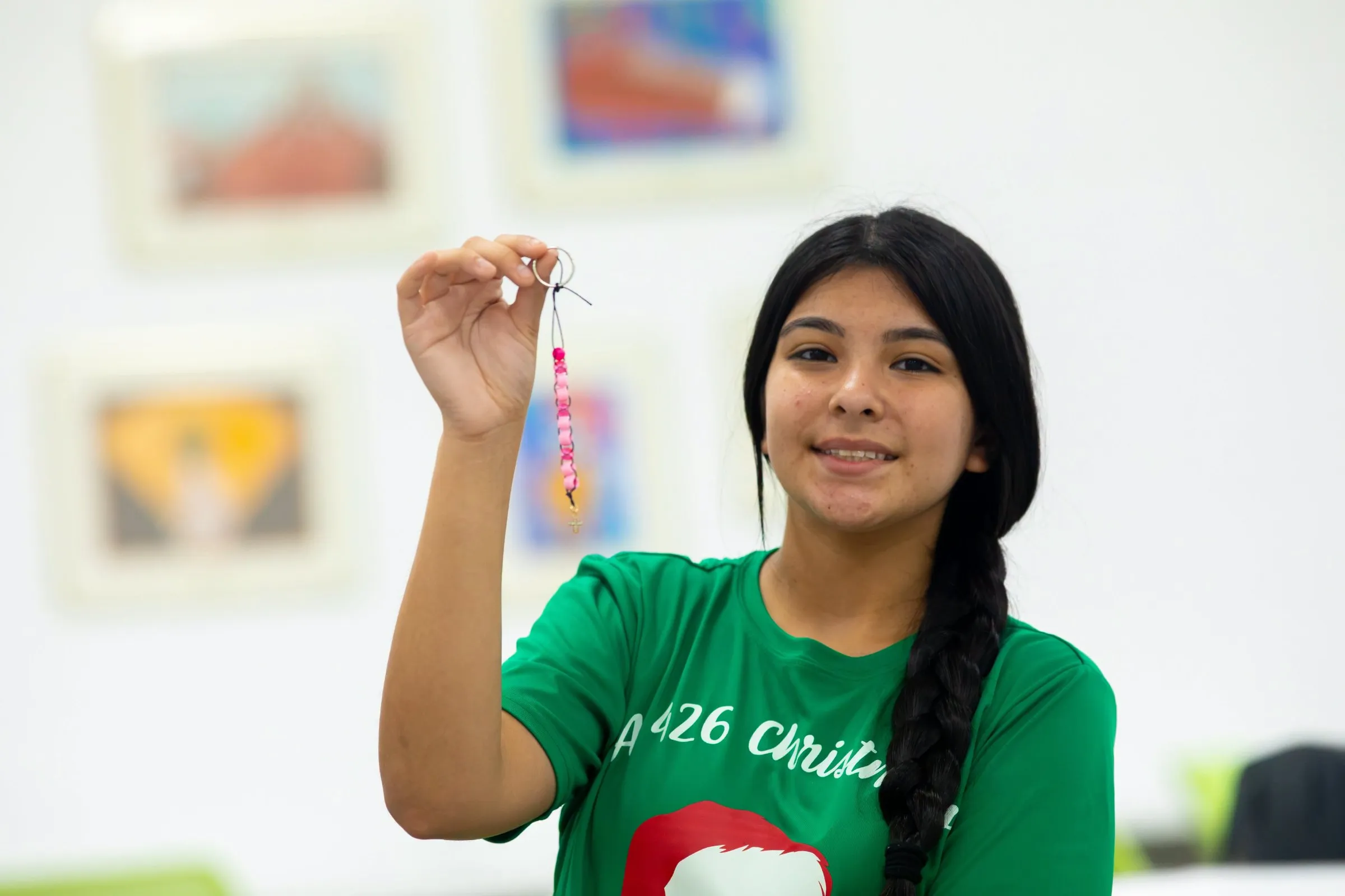 A student holding up the rosary she made