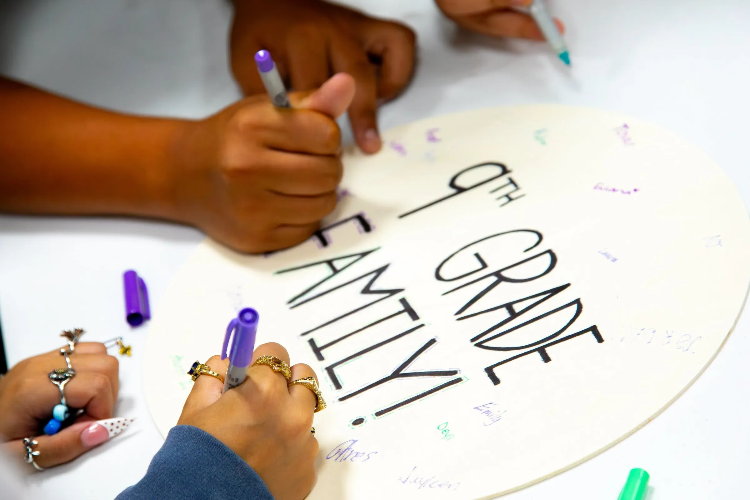 Students decorating a sign that reads 9th grade family