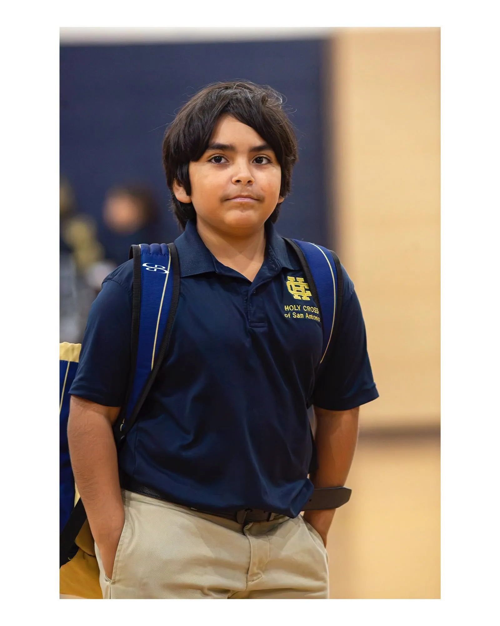 A Holy Cross middle-school student in uniform with his backpack