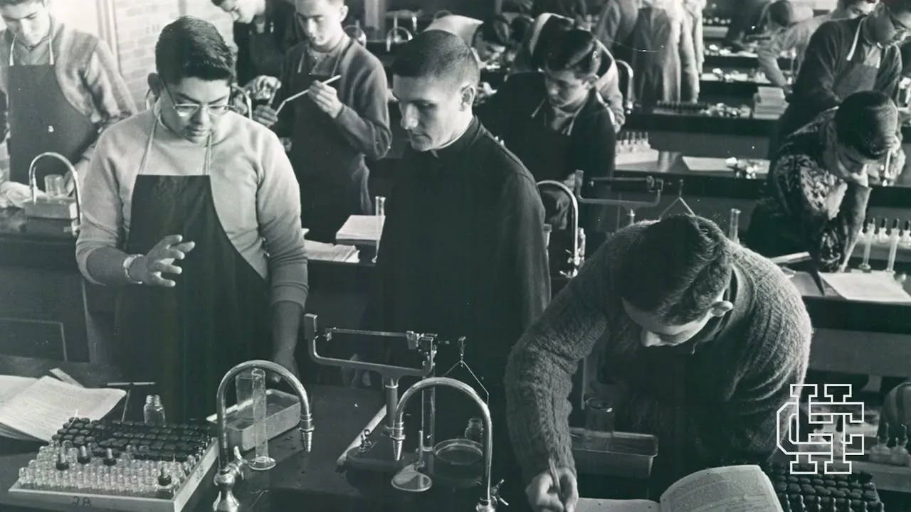 Holy Cross students at typewriters in an early classroom, from the school's Jubilee film